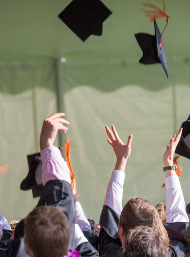 architecture students throwing graduation caps in the air